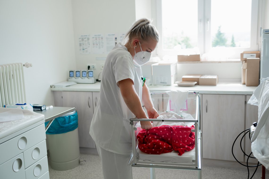 Pflegerin versorgt Neugeborenes