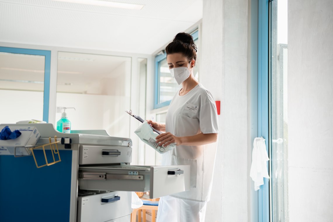 Pflegerin mit steril verpacktem Instrument