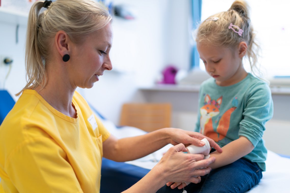 Kinderkrankenschwester mit jungem Mädchen